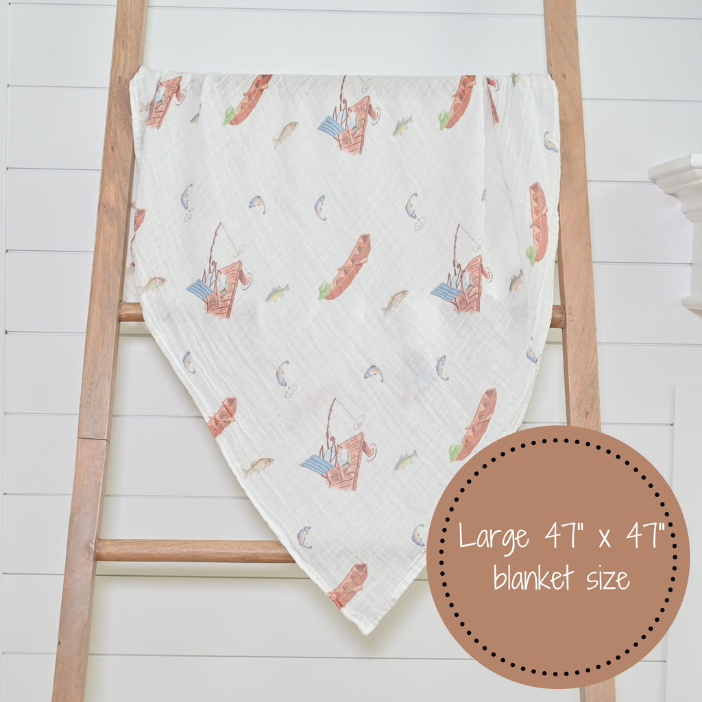 The Go Fishing Adventure 100% Muslin Cotton Swaddle Blanket - 47" x 47" beautifully displayed on a decorative ladder, adding a touch of outdoor charm to any nursery or room.