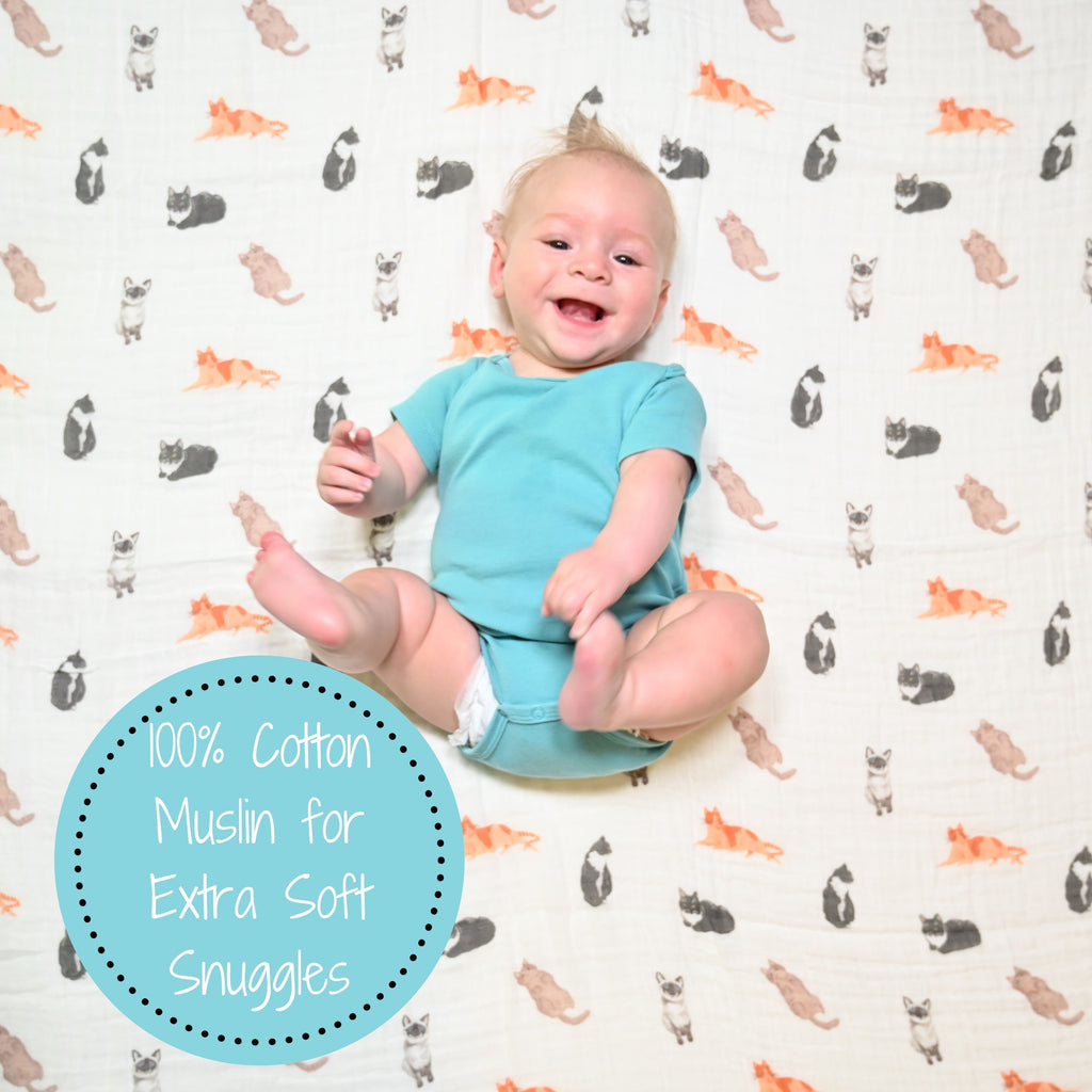 A cheerful baby boy with the Cat Prints Muslin Swaddle Baby Blanket - 47" x 47" , spreading joy and warmth