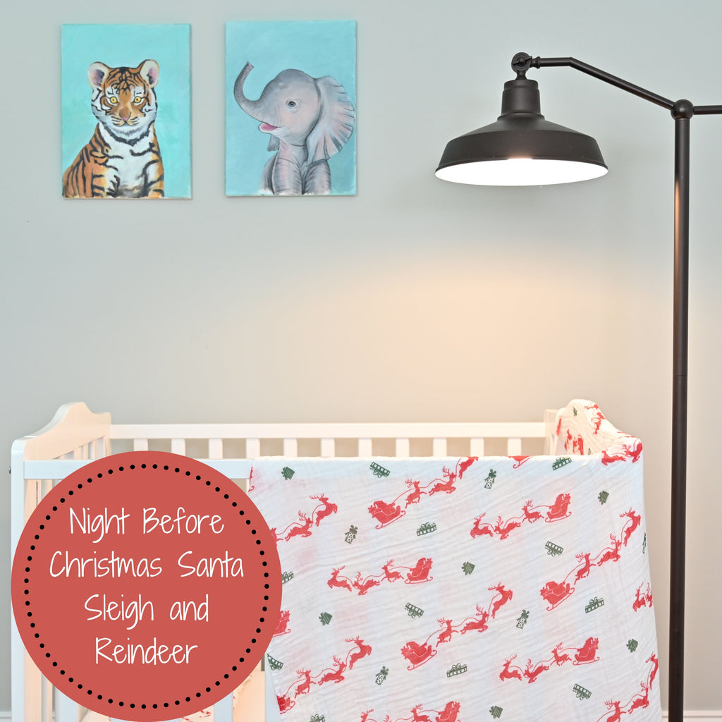 The Santa and Reindeer Muslin Swaddle Blanket - 47" x 47" gracefully draped on a crib, infusing a festive atmosphere into the nursery.