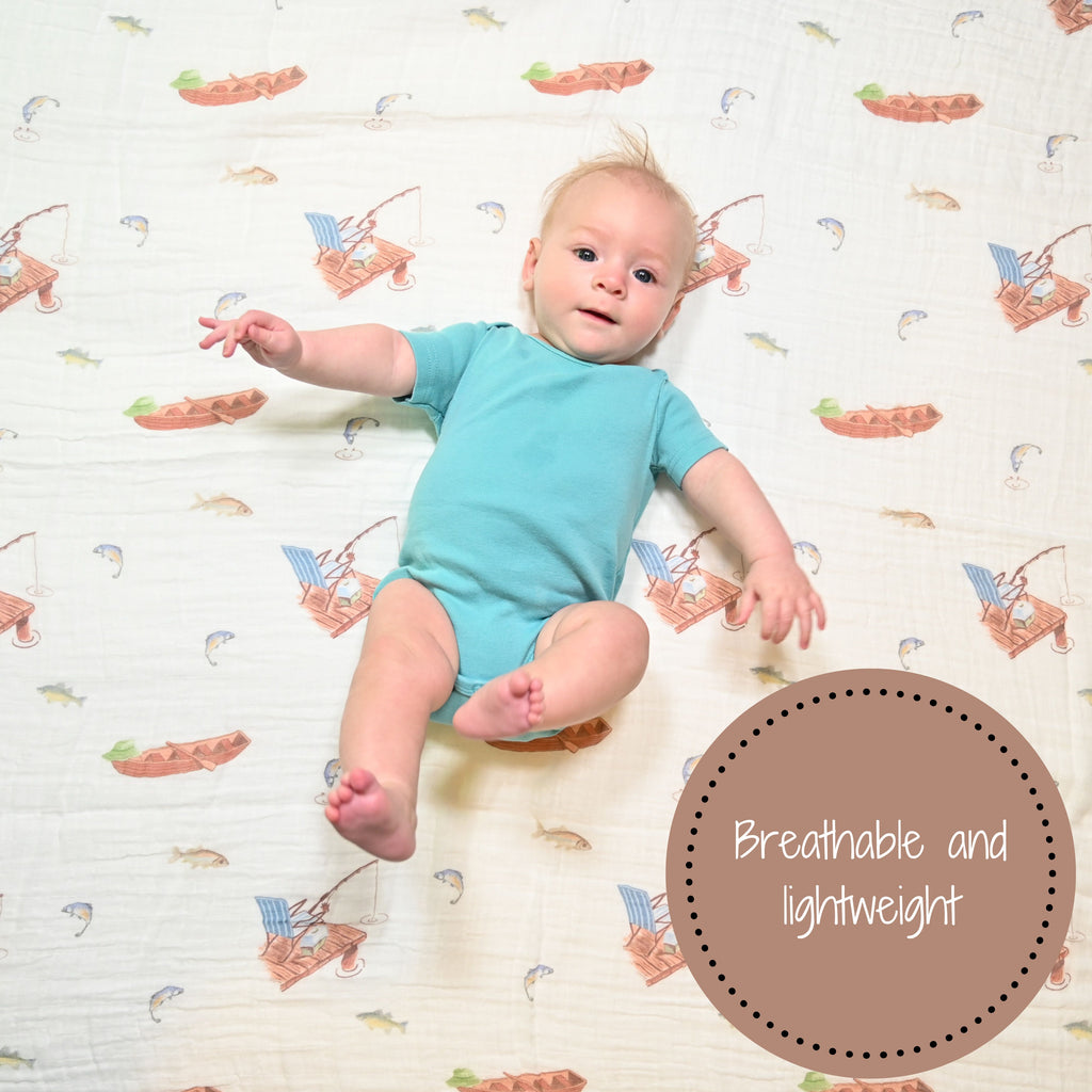 A joyful baby boy with a heartwarming smile, framed by the Go Fishing Adventure 100% Muslin Cotton Swaddle Blanket - 47" x 47", radiating happiness and a love for outdoor adventures.